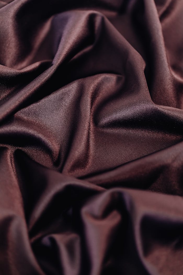 Close-up of luxurious dark purple fabric showcasing its smooth texture and elegant draping.