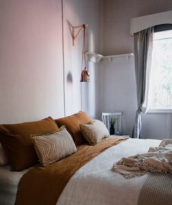 Modern bedroom featuring warm tones, natural light, and minimalist decor for a cozy atmosphere.