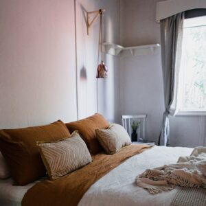 Modern bedroom featuring warm tones, natural light, and minimalist decor for a cozy atmosphere.